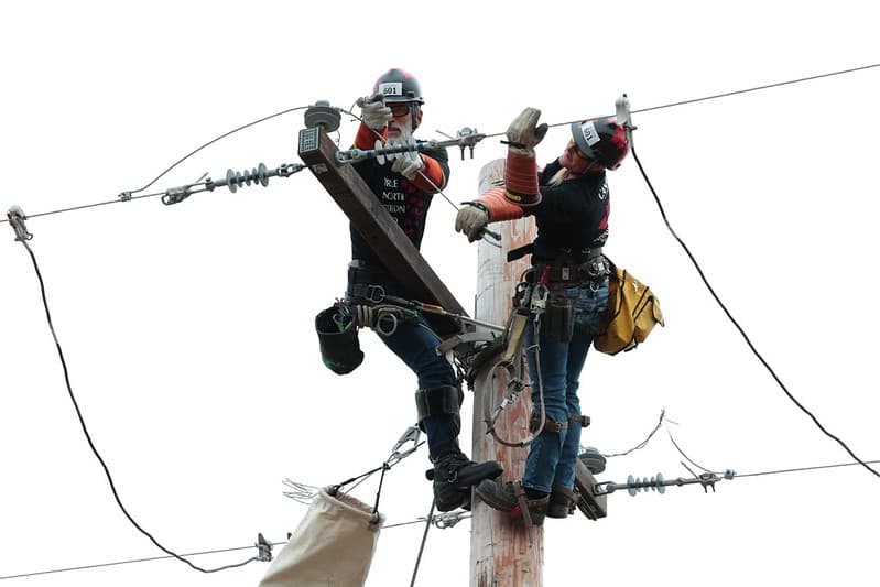 Two linemen competing on a pole at the International Lineman's Rodeo