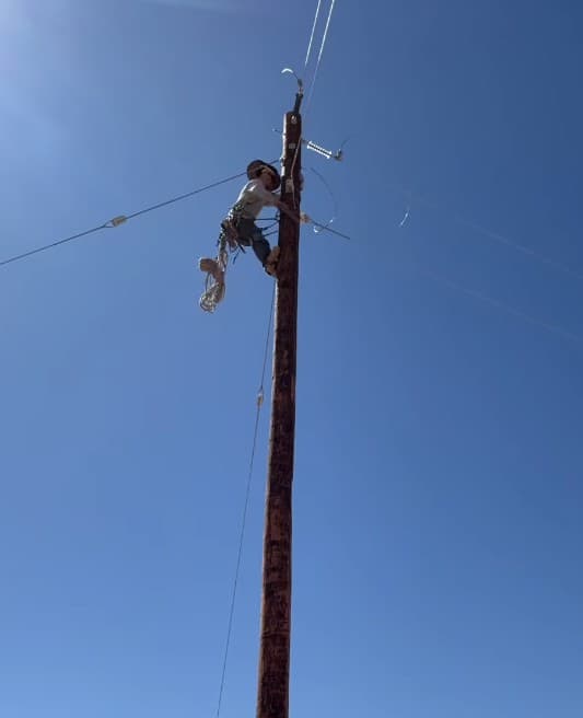 Lineworker climbing an energized pole