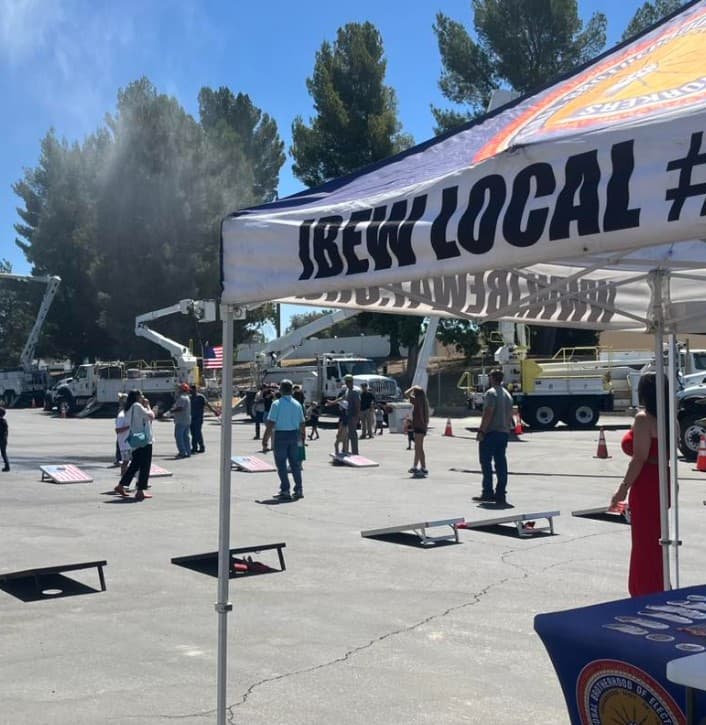IBEW local gathering with bucket trucks lined up behind the crowd