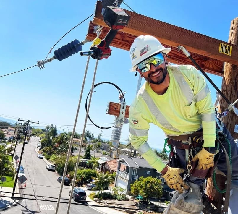 Journeyman lineworker on the pole in full climbing gear