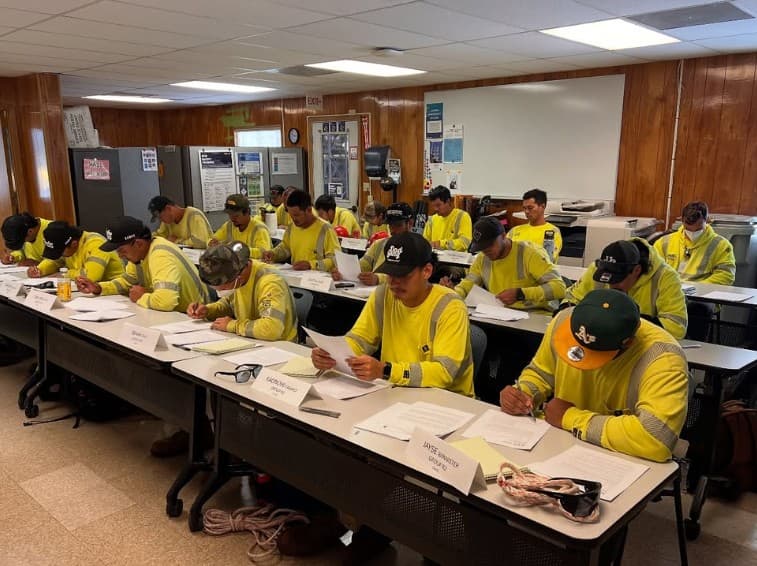 Lineworkers at desks taking a written class
