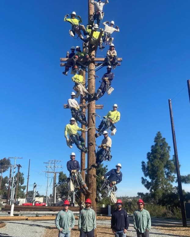 Training class arranged up a climbing pole