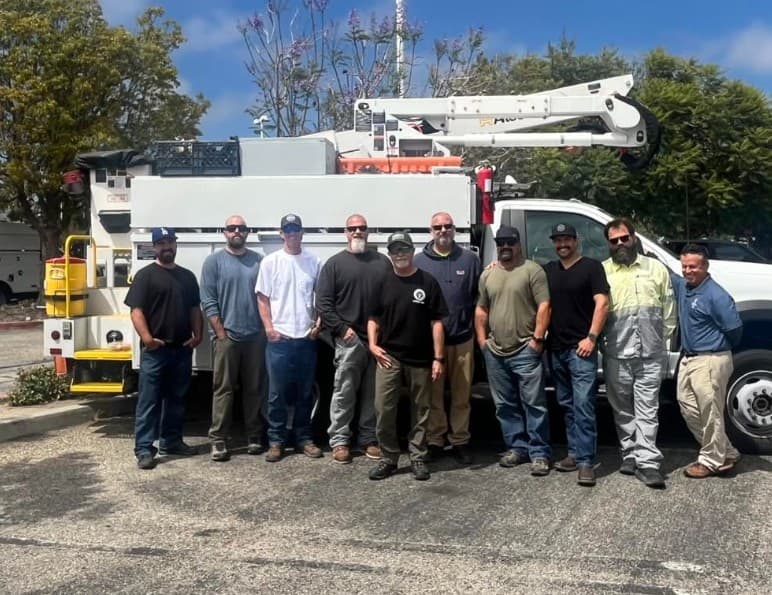 Line crew posed in front of a bucket truck